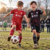 Liverpool Home and Third Gift Pack Kids Football Kits 26/27 - boys wearing kids football kits on UK pitch