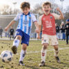 Malaga CF Home and Away Gift Pack Kids Football Kits 26/27 - boys wearing kids football kits on UK pitch